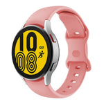 Butterfly buckle silicone watch band for Samsung Galaxy Watch4, pink color, displaying a round watch face.
