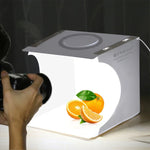 Kit de studio photo portable pliable avec panneau LED annulaire PULUZ de 23 cm, comprenant une tente et 6 fonds de couleur (noir, blanc, jaune, rouge, vert, bleu). Dimensions déplié : 24 cm x 23 cm x 23 cm. Panneau LED annulaire de 23 cm.