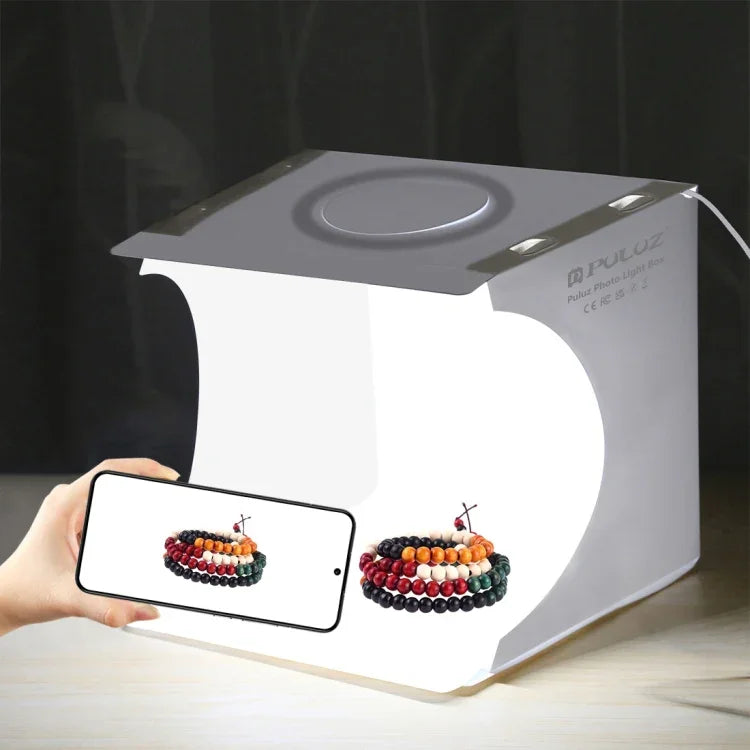 Kit de studio photo portable pliable avec panneau LED annulaire PULUZ de 23 cm, comprenant une tente et 6 fonds de couleur (noir, blanc, jaune, rouge, vert, bleu). Dimensions déplié : 24 cm x 23 cm x 23 cm. Panneau LED annulaire de 23 cm.