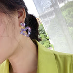 Boucles d'oreilles clou Amour Aiguille d'Argent, E2109-12 Diamant violet, E2109-13 Diamant blanc, E2112-9 Amour asymétrique or, E2112-10 Amour asymétrique K blanc